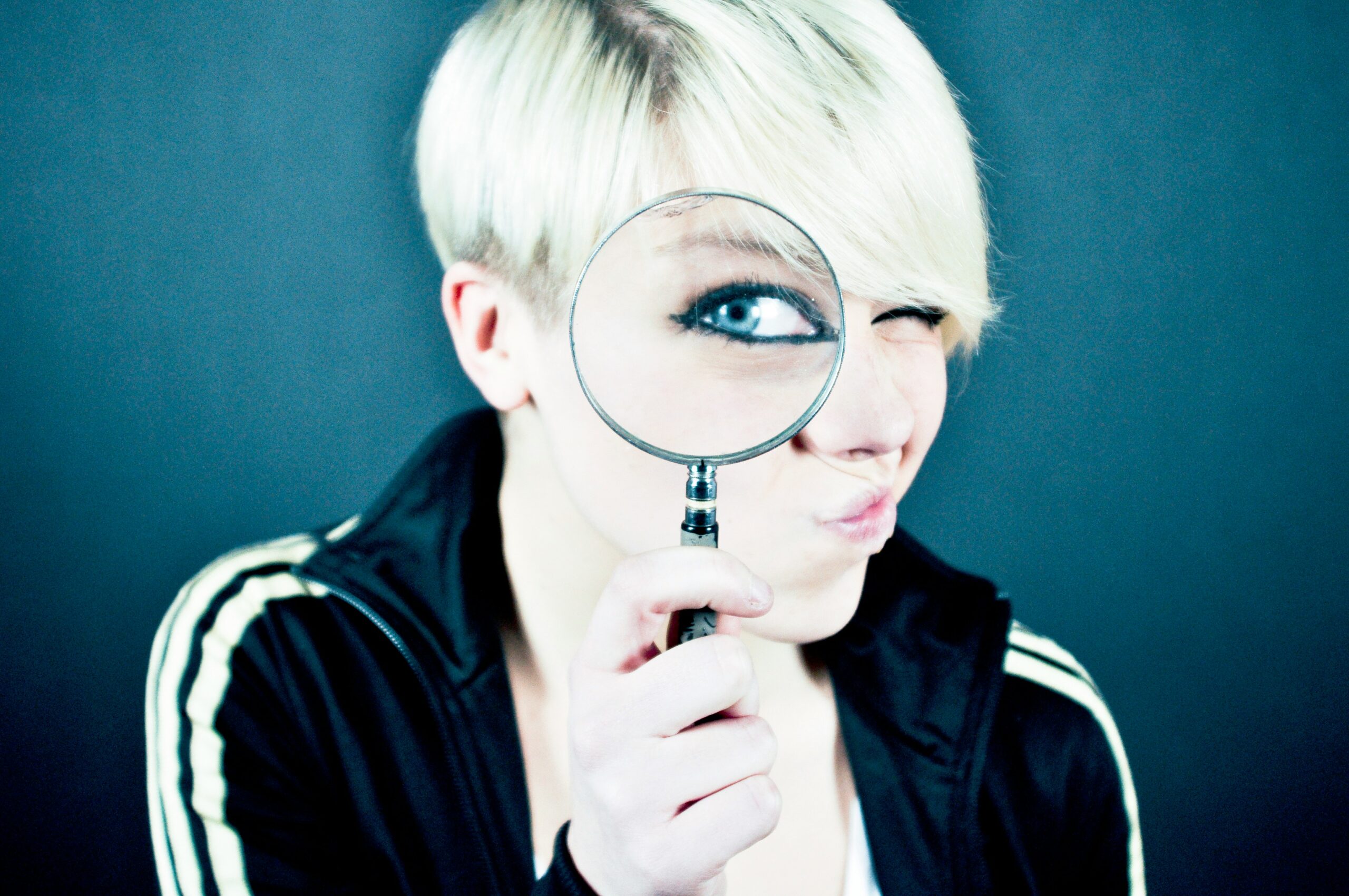 Woman peering through a magnifying glass. Vetting K-12 Edtech.