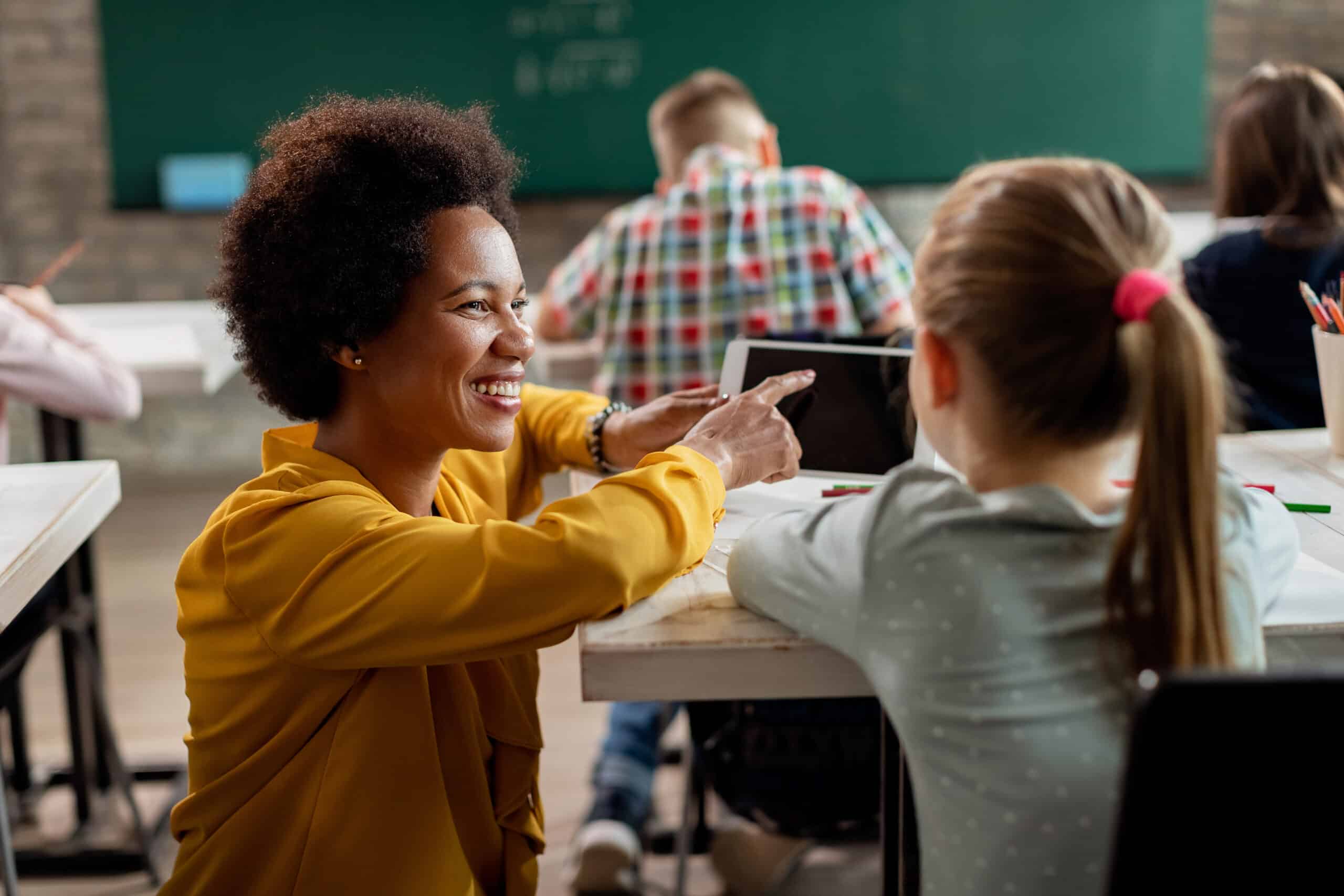 Teacher helping student at desk